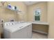 Well-lit laundry room featuring a washer, dryer, and folding table for easy laundry management at 705 Quintan St, Summerville, SC 29486