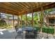 Shaded outdoor patio space features a wooden pergola and a metal table with chairs at 712 Wakendaw Blvd, Mount Pleasant, SC 29464