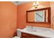 Orange powder room with decorative mirror and single vanity at 712 Wakendaw Blvd, Mount Pleasant, SC 29464