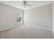 Bright bedroom features neutral walls, carpet flooring, a ceiling fan, and natural light from the window at 7511 Hawks Cir, Hanahan, SC 29410