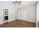 Spacious bedroom showcasing the ensuite bathroom and closet entries, with wood flooring and a ceiling fan at 7511 Hawks Cir, Hanahan, SC 29410