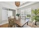 Bright dining room with a decorative chandelier, large window, plants and a stylish table for six at 7511 Hawks Cir, Hanahan, SC 29410