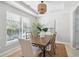 Bright dining room with a decorative chandelier, large window and a stylish table for six at 7511 Hawks Cir, Hanahan, SC 29410