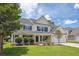 Inviting two-story home with a charming front porch, attached garage and lush landscaping at 7511 Hawks Cir, Hanahan, SC 29410
