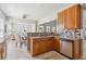 Well-lit kitchen with wooden cabinets, stainless appliances, and a view into the living room at 7511 Hawks Cir, Hanahan, SC 29410