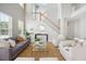 Well-lit living room with tall windows, cozy seating, and a staircase with wood railing at 7511 Hawks Cir, Hanahan, SC 29410