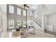 Bright living room with large windows, high ceilings, and elegant staircase at 7511 Hawks Cir, Hanahan, SC 29410