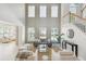 Sun-filled living room with soaring ceilings, neutral decor and beautiful staircase at 7511 Hawks Cir, Hanahan, SC 29410