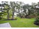 Lush backyard featuring mature trees, green lawn, and a fence, creating a private outdoor oasis at 774 Creekside Dr, James Island, SC 29412
