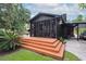 Backyard featuring a wooden deck, a screened-in porch, lush landscaping, and a convenient carport at 774 Creekside Dr, James Island, SC 29412