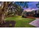 Backyard featuring a spacious lawn, mature trees with string lights, a cozy porch, and a deck for relaxation at 774 Creekside Dr, James Island, SC 29412