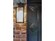 Close up view of the front door with brick siding, hardware, and an outdoor light at 774 Creekside Dr, James Island, SC 29412