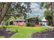 Beautiful home exterior with a well-manicured lawn, mature trees, and a spacious deck at 774 Creekside Dr, James Island, SC 29412