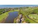 Beautiful aerial view of a lakeside home, surrounded by lush greenery, golf course, and ocean backdrop at 930 Sealoft Villa Dr, Seabrook Island, SC 29455