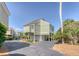 Inviting coastal home with light green siding, elevated design, and scenic surroundings with beautiful landscaping at 930 Sealoft Villa Dr, Seabrook Island, SC 29455