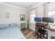 Cozy bedroom with sleek wood flooring, a desk, and a large window providing natural light at 9836 Black Tupelo Ln, Ladson, SC 29456