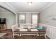 Bright dining room with crown molding, a large dining table, wainscotting and two windows for natural light at 9836 Black Tupelo Ln, Ladson, SC 29456