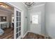 Inviting entryway featuring wood-look floors, a white front door with glass panes, and stylish, light-green painted walls at 9836 Black Tupelo Ln, Ladson, SC 29456