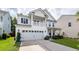 Charming two story home has white siding, a large garage, and second story balcony at 9836 Black Tupelo Ln, Ladson, SC 29456
