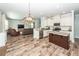 Open-concept kitchen with an island, stainless steel appliances, and stylish finishes, flowing into the living area at 9836 Black Tupelo Ln, Ladson, SC 29456
