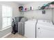 Well-lit laundry room with shelving and full-sized washer and dryer at 9836 Black Tupelo Ln, Ladson, SC 29456