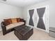 Cozy living room featuring a comfy sofa, ottoman, and stylish double doors with curtains at 9836 Black Tupelo Ln, Ladson, SC 29456