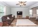 Cozy living room featuring wood-look floors, comfortable seating, and a large window for natural light at 9836 Black Tupelo Ln, Ladson, SC 29456