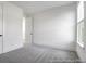 This bedroom has gray carpet, white walls, a window for natural light, and a door leading to another room at 1023 Marsh Harrier Dr # Cc3-3-5P, Ravenel, SC 29470