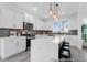 Modern kitchen features white cabinets, stainless steel appliances, a gray backsplash, and a spacious island with seating at 1023 Marsh Harrier Dr # Cc3-3-5P, Ravenel, SC 29470