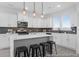 Modern kitchen with white cabinets, stainless steel appliances, a gray backsplash, and a spacious island with seating at 1023 Marsh Harrier Dr # Cc3-3-5P, Ravenel, SC 29470