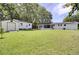 Beautiful backyard with green grass, sheds, and screened in back porch at 1032 Windward Rd, Charleston, SC 29412