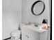 Clean bathroom with white vanity, round mirror, and modern fixtures at 1032 Windward Rd, Charleston, SC 29412