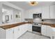 Modern kitchen features white cabinets, stainless steel appliances, butcher block countertops, and stylish finishes at 1032 Windward Rd, Charleston, SC 29412