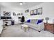 Bright living room featuring gray sofa, dual monitor desk setups, and modern decor at 1032 Windward Rd, Charleston, SC 29412
