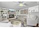 Cozy living room with white brick fireplace, mounted TV, plush seating, and decorative shelving at 1032 Windward Rd, Charleston, SC 29412
