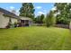 Well-maintained backyard showcasing a spacious lawn, a screened porch, and mature trees, ideal for outdoor activities and entertaining at 104 Lancaster Ct, Goose Creek, SC 29445