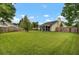 A well-maintained backyard featuring a lush green lawn, a screened-in porch, and a surrounding wooden fence for privacy at 104 Lancaster Ct, Goose Creek, SC 29445