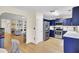 Open kitchen with stainless steel appliances and blue cabinets, flowing into living area at 104 Lancaster Ct, Goose Creek, SC 29445