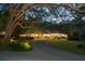 Beautiful brick home with a circular driveway and meticulously maintained landscaping at dusk at 108 E Walker Dr, Summerville, SC 29483