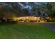 Beautiful brick home with a circular driveway and meticulously maintained landscaping at dusk at 108 E Walker Dr, Summerville, SC 29483