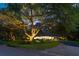 Charming home featuring a circular driveway, lush lawn, mature trees and landscape lighting at 108 E Walker Dr, Summerville, SC 29483