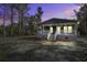 Charming single-story home featuring a covered porch, grey siding, and a well-maintained yard under a vibrant evening sky at 108 Wisteria Falls Ln, Saint Stephen, SC 29479