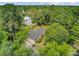 Stunning aerial view of a landscaped property with a circular driveway, blue chairs, and a charming brick home surrounded by lush trees at 110 W 2Nd South St, Summerville, SC 29483