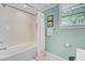 Bathroom features a white tiled shower and tub, as well as a bright window with natural light at 110 W 2Nd South St, Summerville, SC 29483
