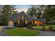 Charming home with a cozy fire pit area, manicured landscaping, and warm lighting that enhance its inviting curb appeal at 110 W 2Nd South St, Summerville, SC 29483