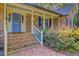 Inviting covered front porch with brick stairs, white railings, and a blue front door, showcasing classic architectural details at 110 W 2Nd South St, Summerville, SC 29483