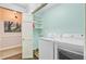 Bright laundry room with modern white washer and dryer, shelving, and artwork adding a touch of elegance at 110 W 2Nd South St, Summerville, SC 29483