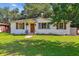Charming white brick home featuring manicured lawn, wood shutters, and inviting front porch at 111 Circle Dr, Summerville, SC 29485