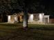 White brick home at night featuring stylish exterior lighting, manicured lawn, and brick accents at 111 Circle Dr, Summerville, SC 29485