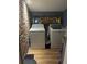 Small laundry room features brick accent wall, shelving, washer, and dryer at 111 Circle Dr, Summerville, SC 29485